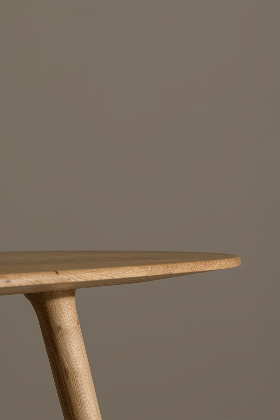 Om de tafel een slankere uitstraling te geven, frezen we een diepe schuine rand in de onderkant van het blad. Door dit detail behoudt het de uitstraling van stevig massief hout en het creëert tegelijk een lichte uitstraling in de eetkamer.