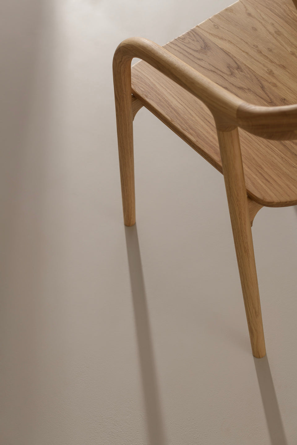 Sculptural armrests shaped in solid oak, walnut, or smoked ash.